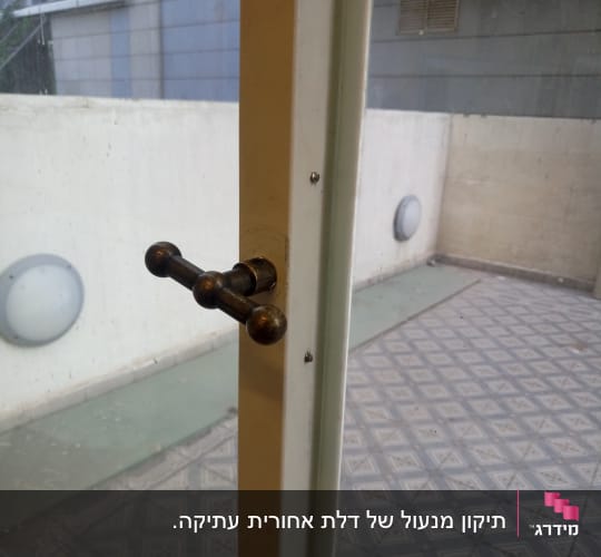 ידית דלת מתכתית על דלת זכוכית